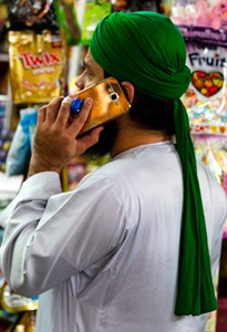 India-Mumbai-Shopkeeper-On-Cell-Phone